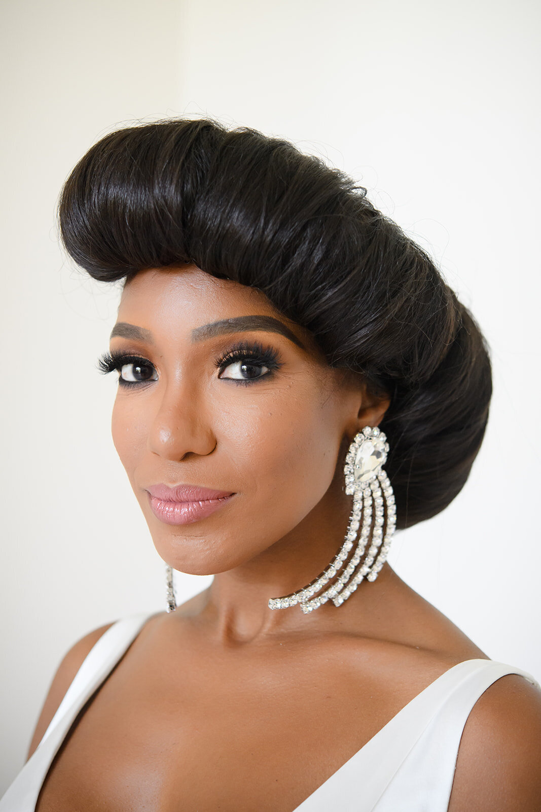 Close-up of the bride with an elegant updo and pearl earrings.