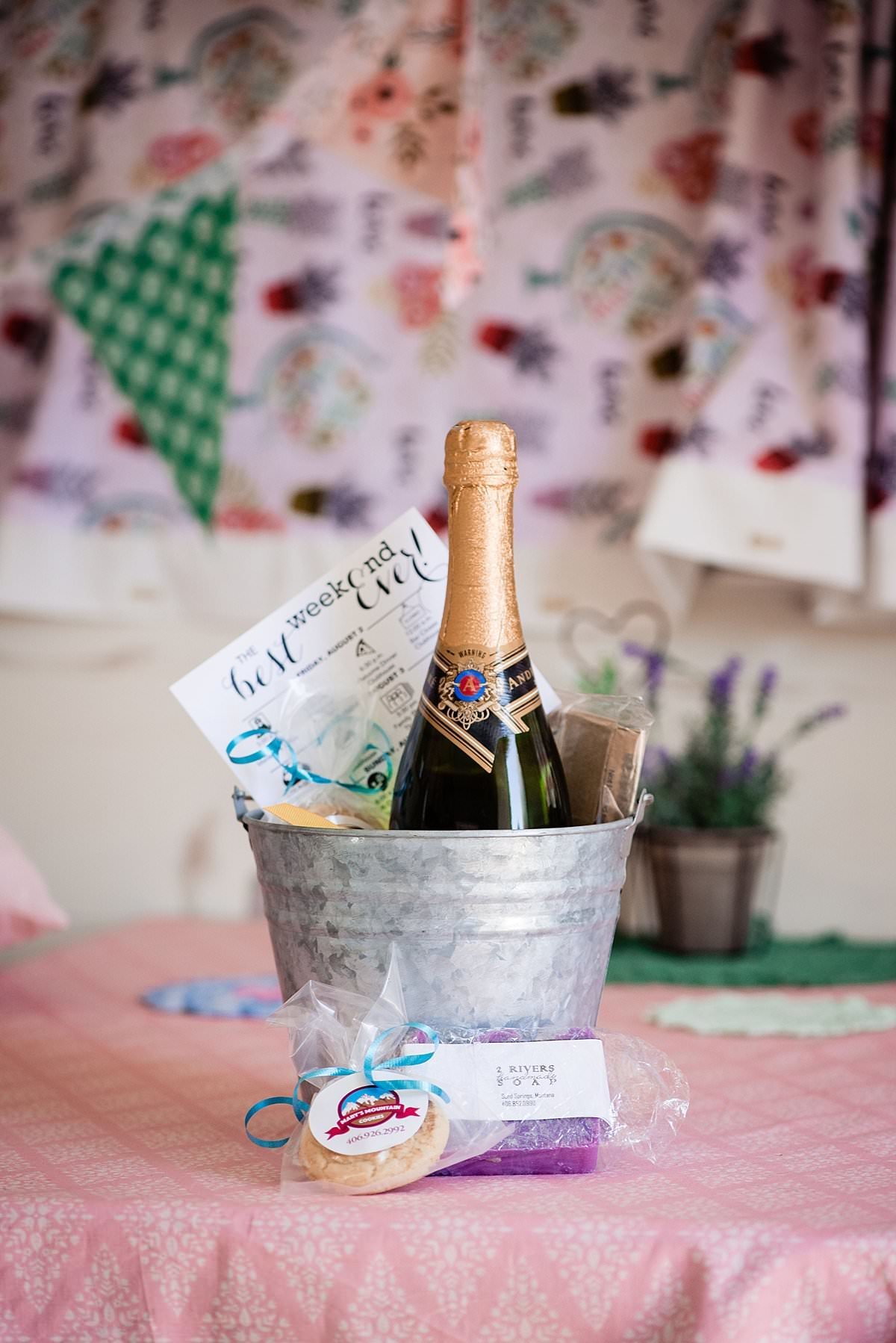 Bucket filled with Montana inspired gifts for wedding guests upon their arrival including a timeline and bottle of champagne