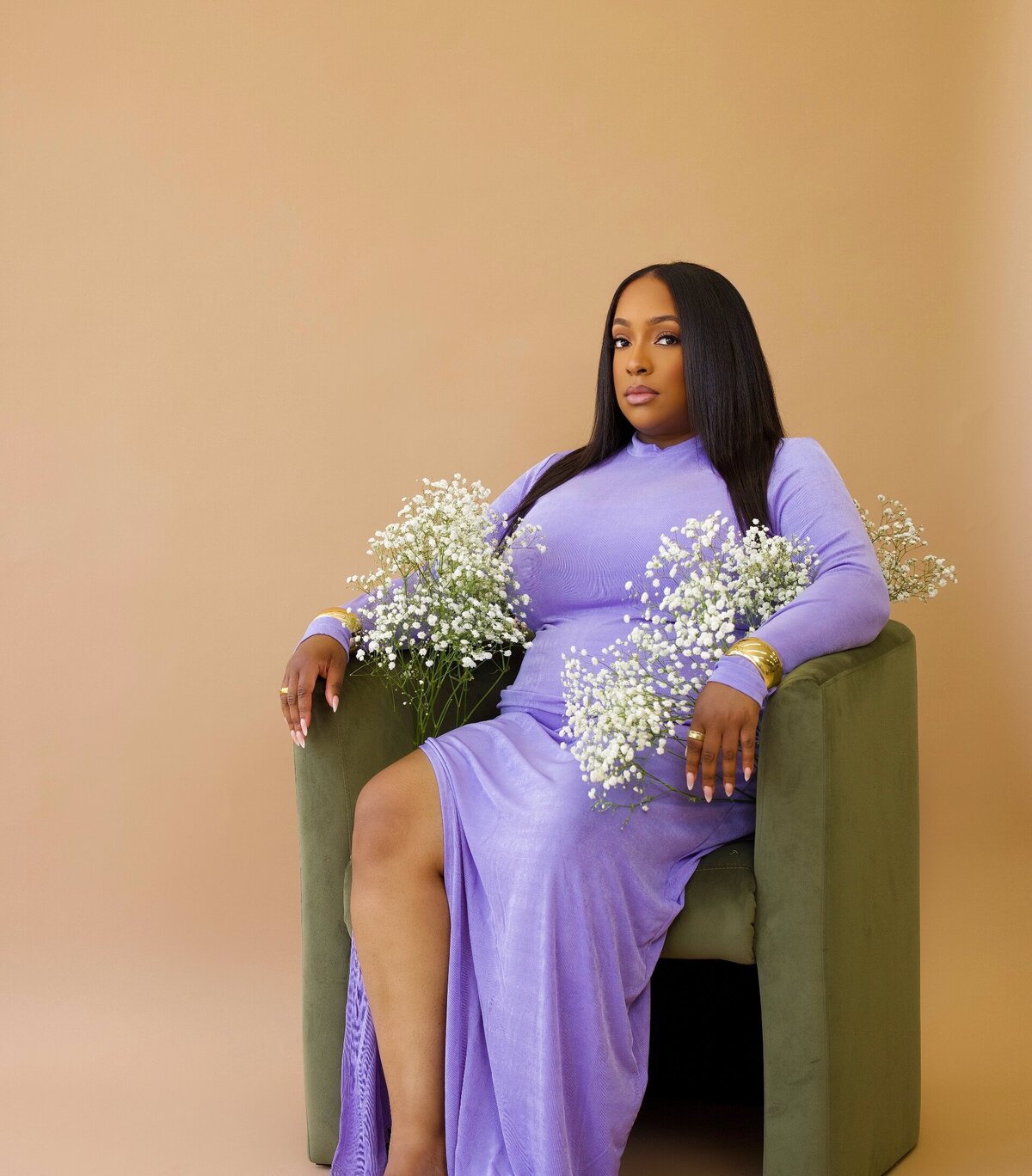 wellness and self help author nakeia homer sitting in green chair while wearing a purple dress
