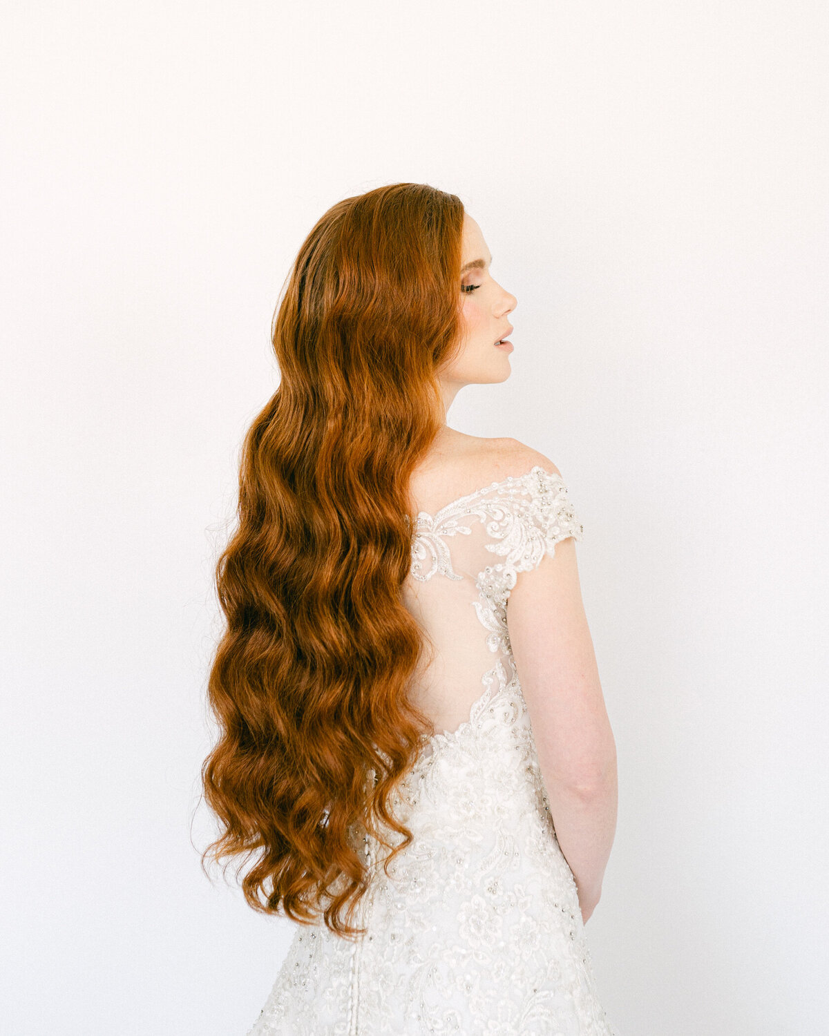 Profile portrait of a bride with long red hair.