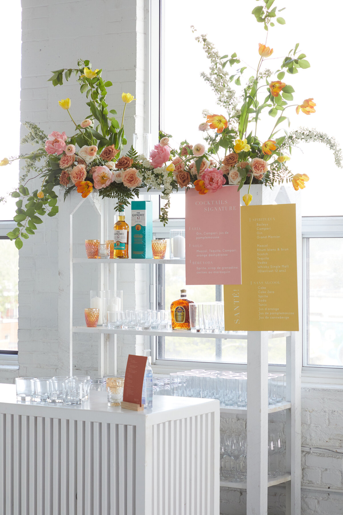 A colourful, modern flower arrangement sits on a wedding barback at L’Eloi. 