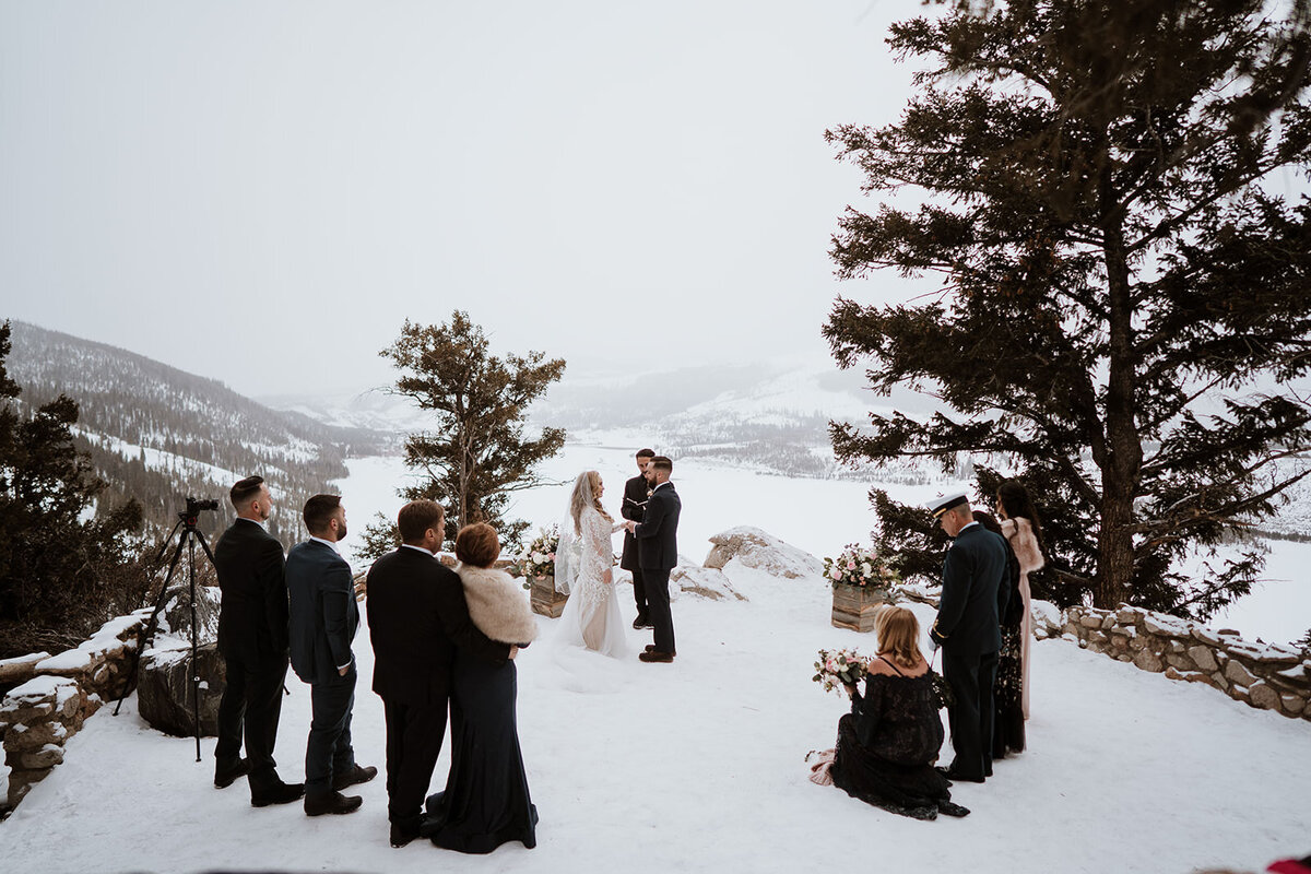 Wide view of intimate snowy wedding ceremony with Breckenridge mountain backdrop.