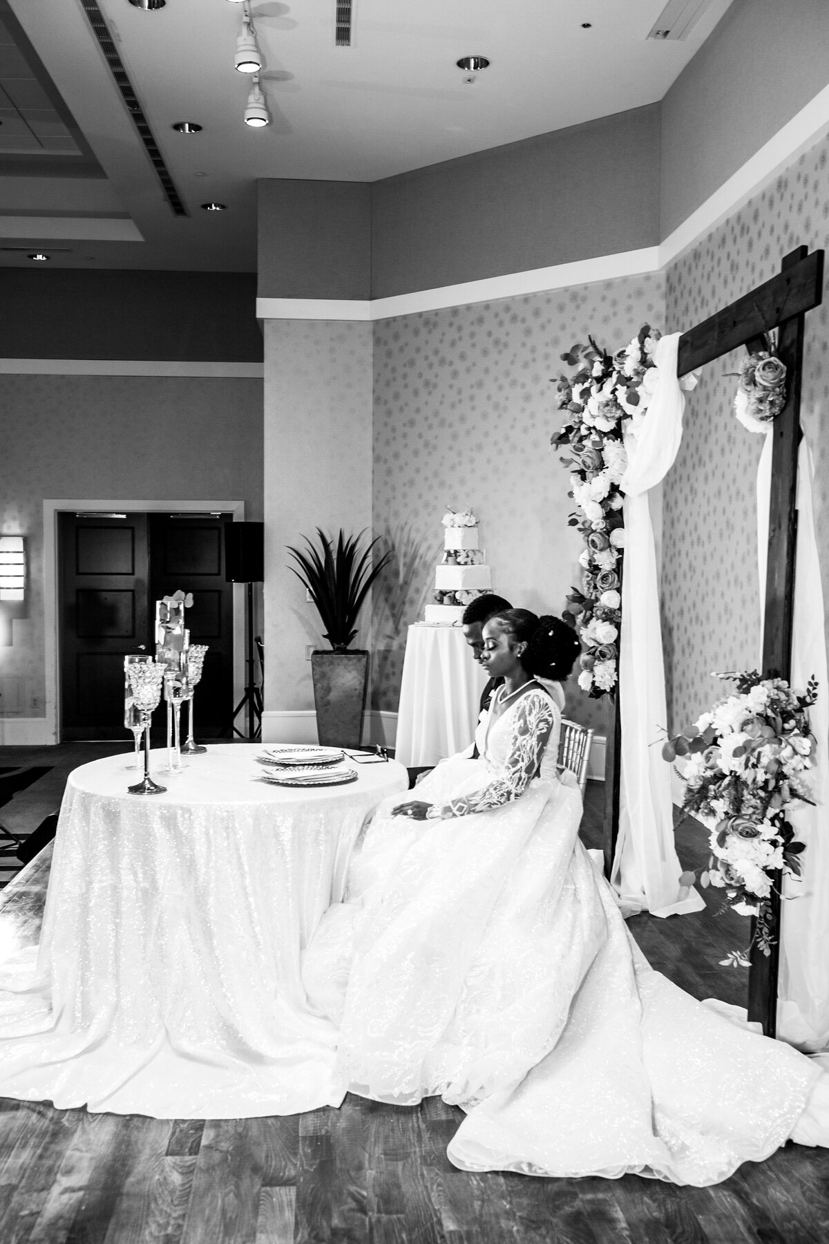 Bride-and-groom-seated-reception-moment-editorial-black-and-white