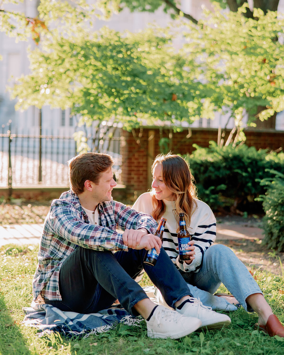 A couple sitting in the grass laughing together 