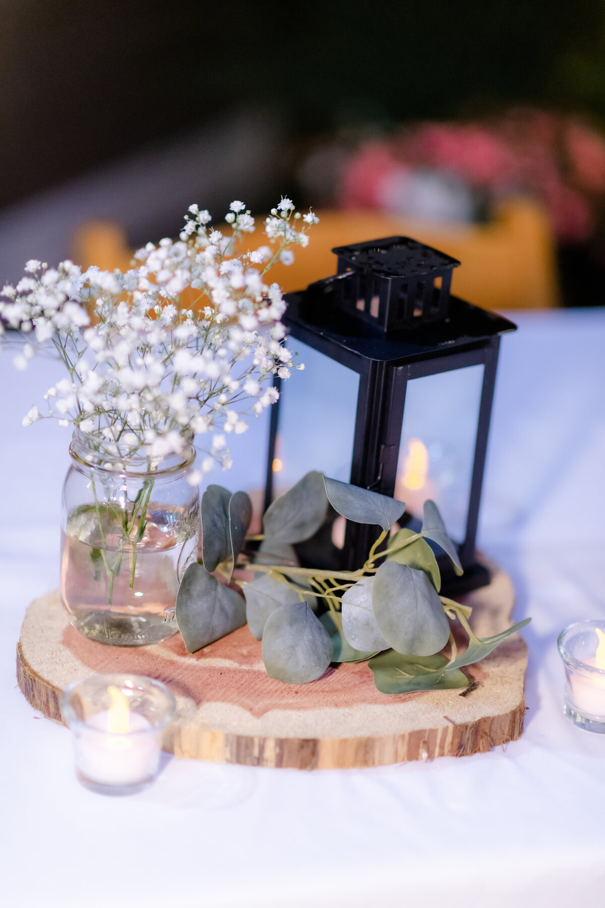 little rock arkansas wedding reception centerpiece with black lantern, eucalyptus leaves and babies breathe