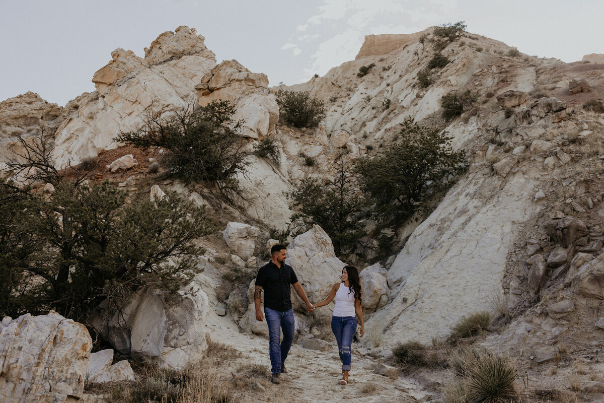 engaged couple walking in the desert