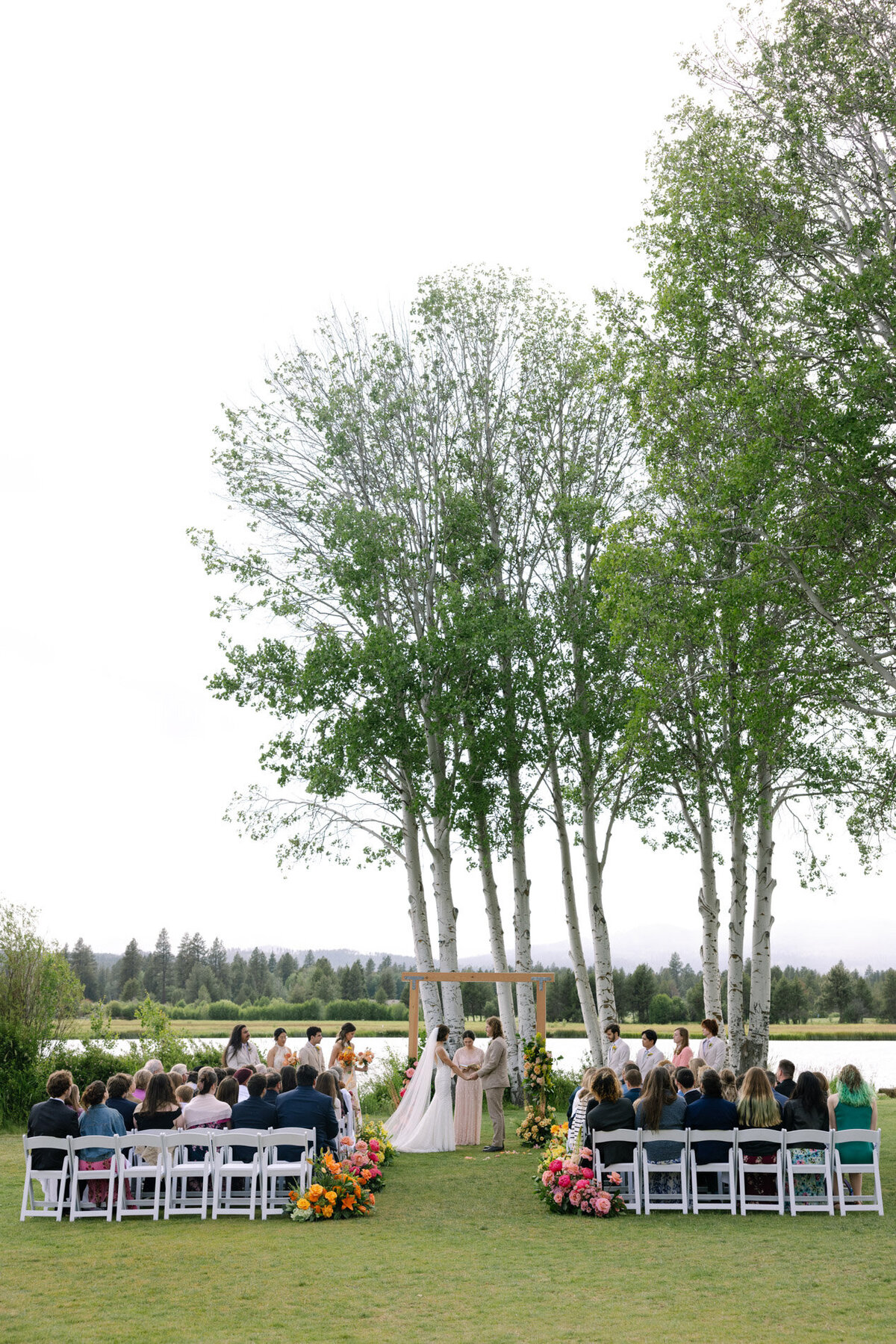 Oregon wedding ceremony setup with views of the sisters mountains, trees and florals in the aisle representing full service design and calligraphy by Life in Letters.