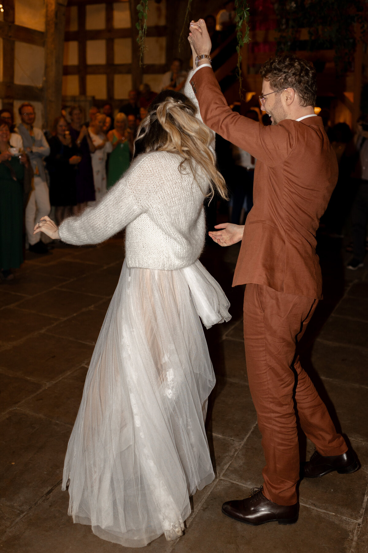 The bride and groom dance  in the Wool Barn at Frampton Court Estate, Gloucestershire