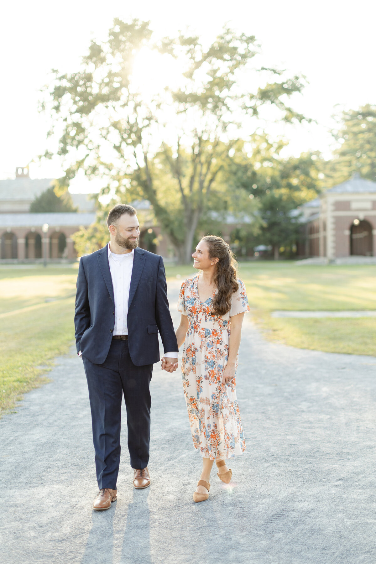 Engaged couple walks hand in hand along a path
