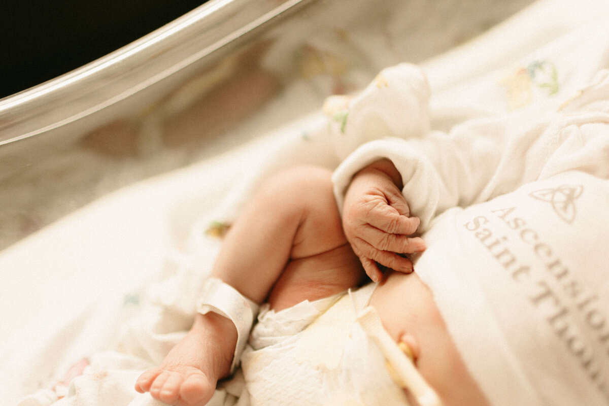 Parents gazing at newborn wrapped in hospital blanket in Nashville.