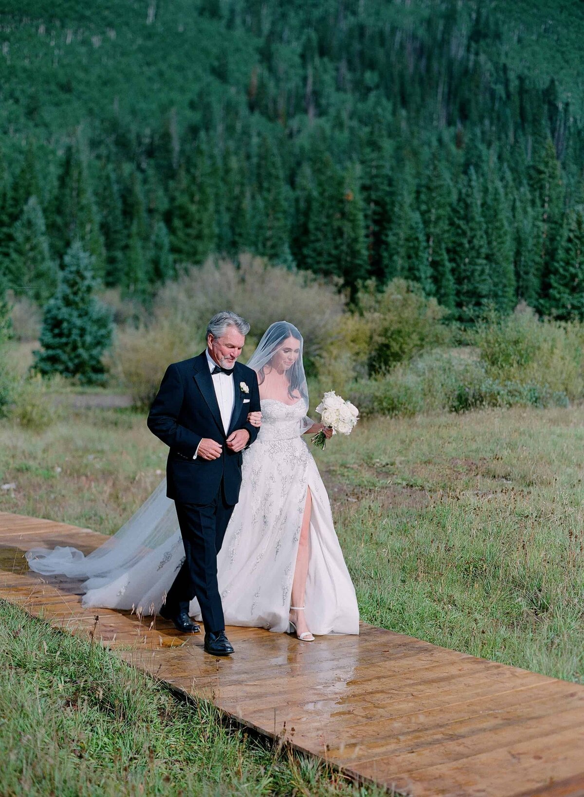 Bride walking down a custom aisle at an outdoor Colorado wedding venue