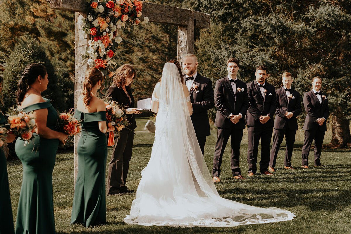 Bellevue Barn wedding ceremony with florals on the arbor
