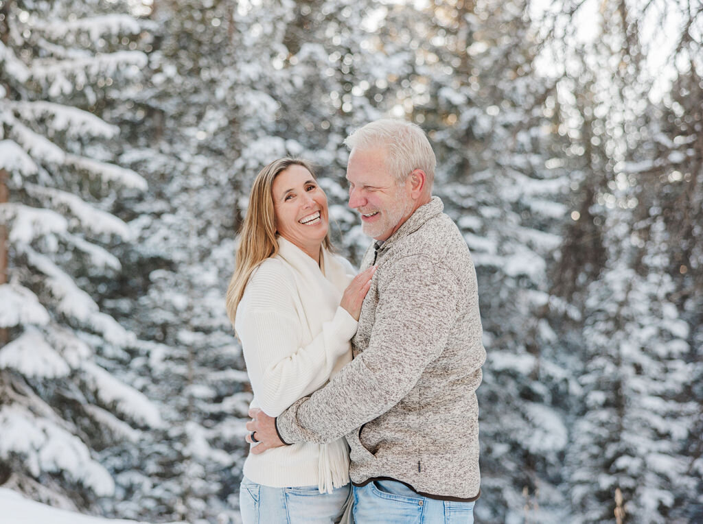 A happy couple laughs in a snow covered Boreas Pass with their Breckenridge Couples Photographer