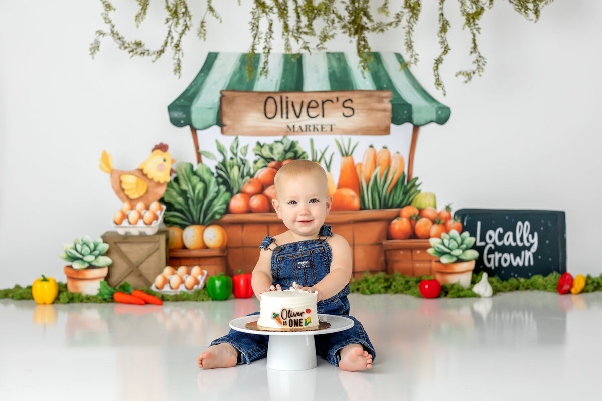 One year old Tampa baby enjoying a personalized luxury cake smash session with farmers market themed decorations