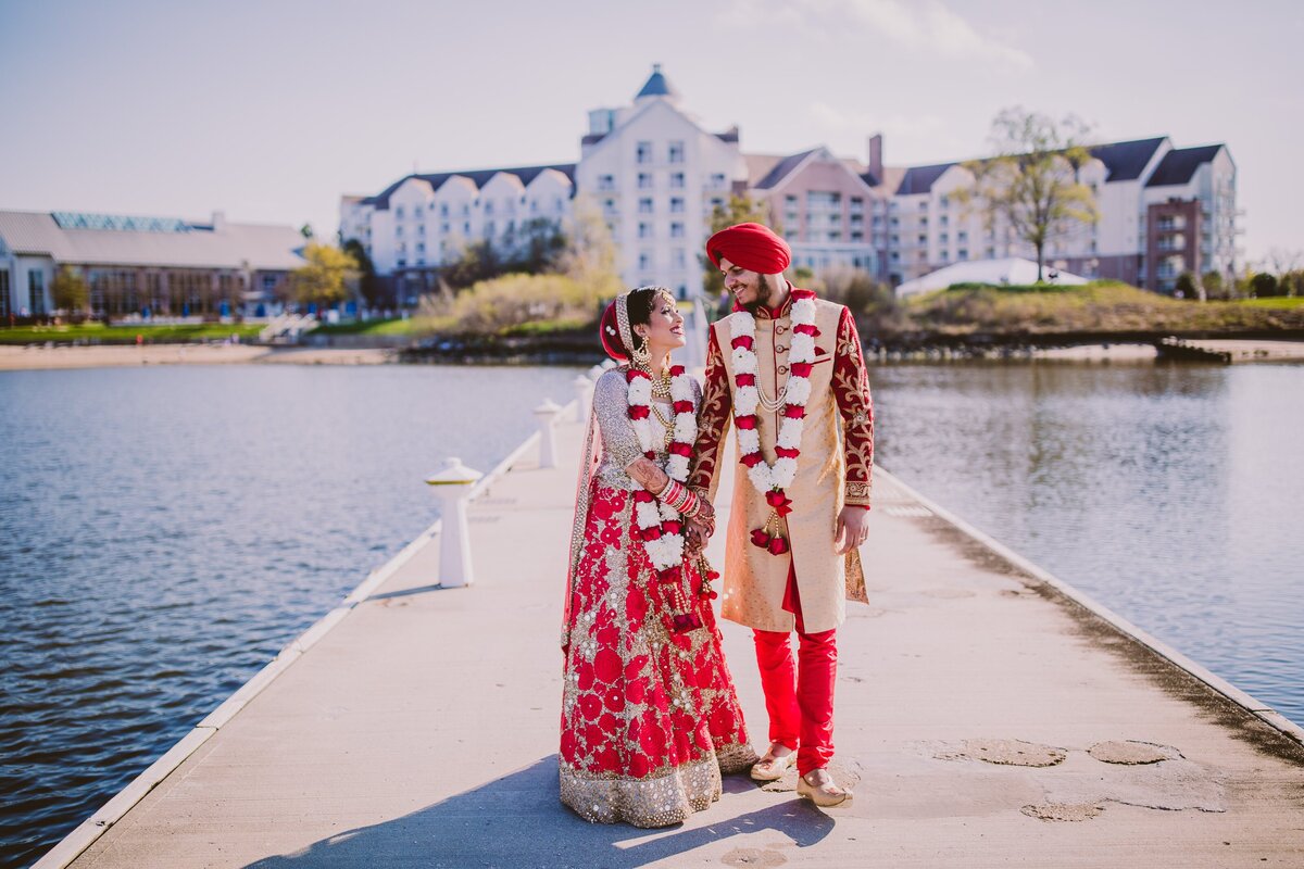 A sikh and hindu bride and groom walking along the pier at the hyatt chesapeake bay in maryland after the wedding