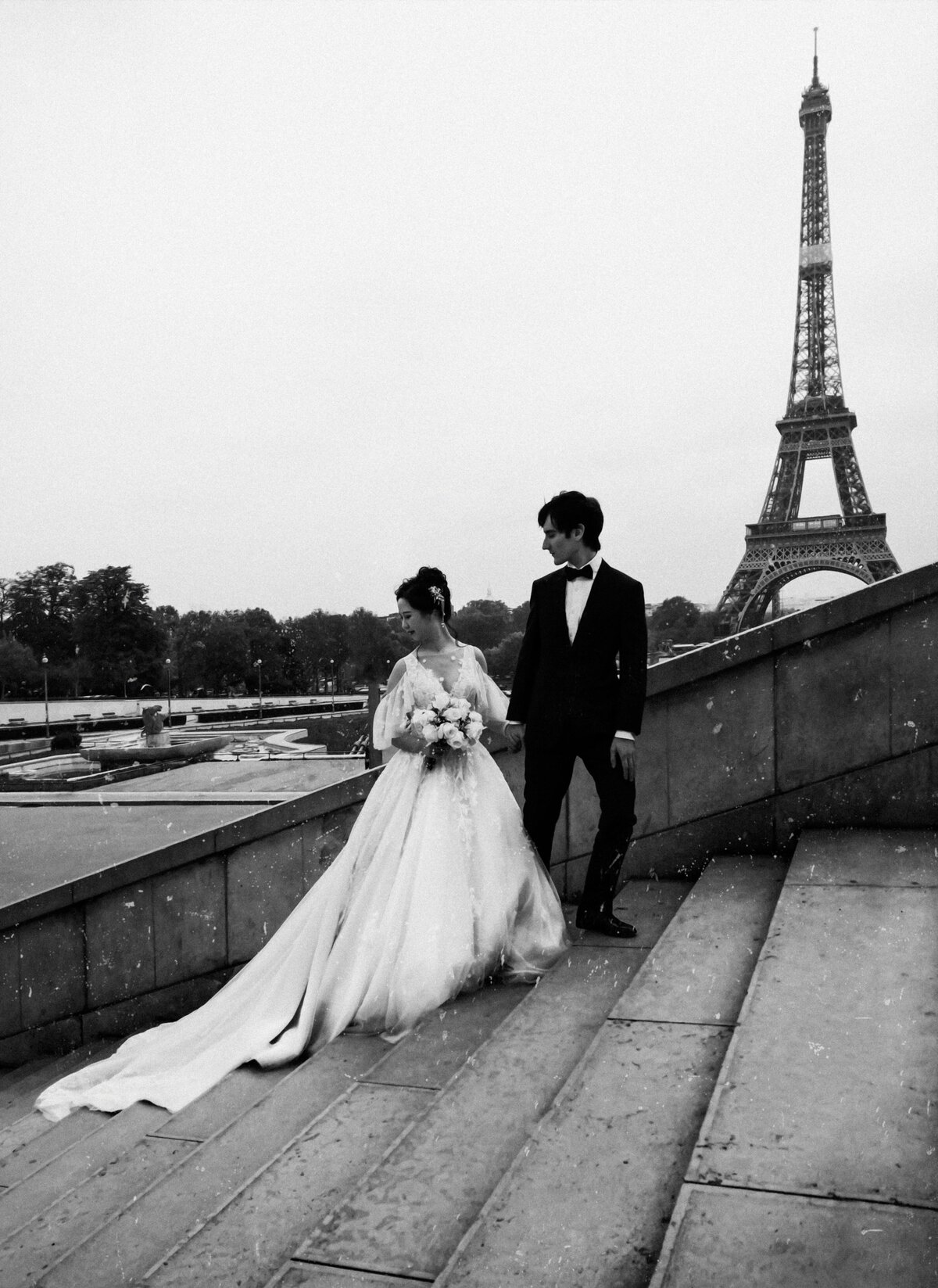 Bride and Groom walk up the staircase near the Eiffel Tower
