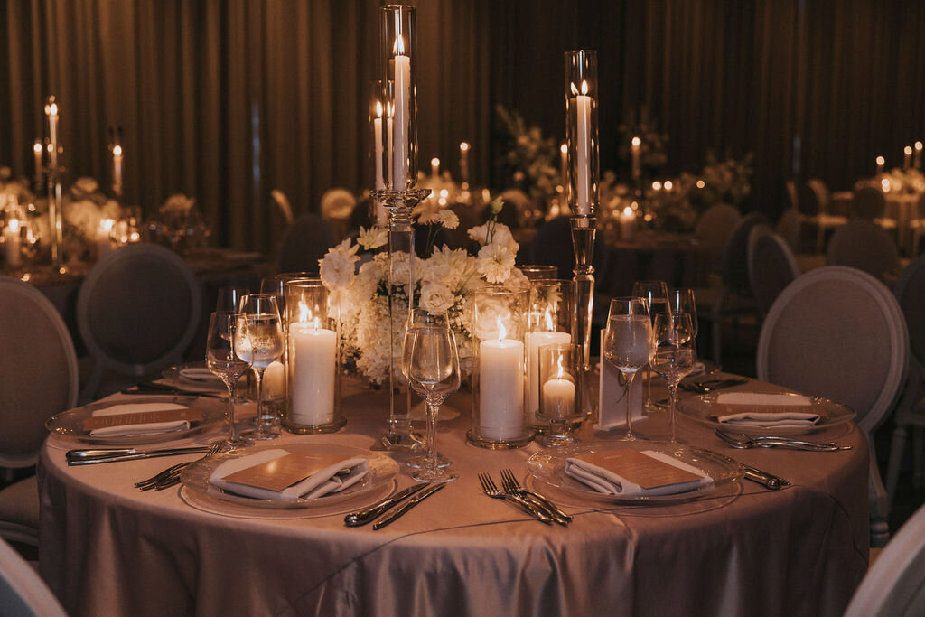 An intimate table setting at a Theatre St James wedding reception featuring a white floral centrepiece.