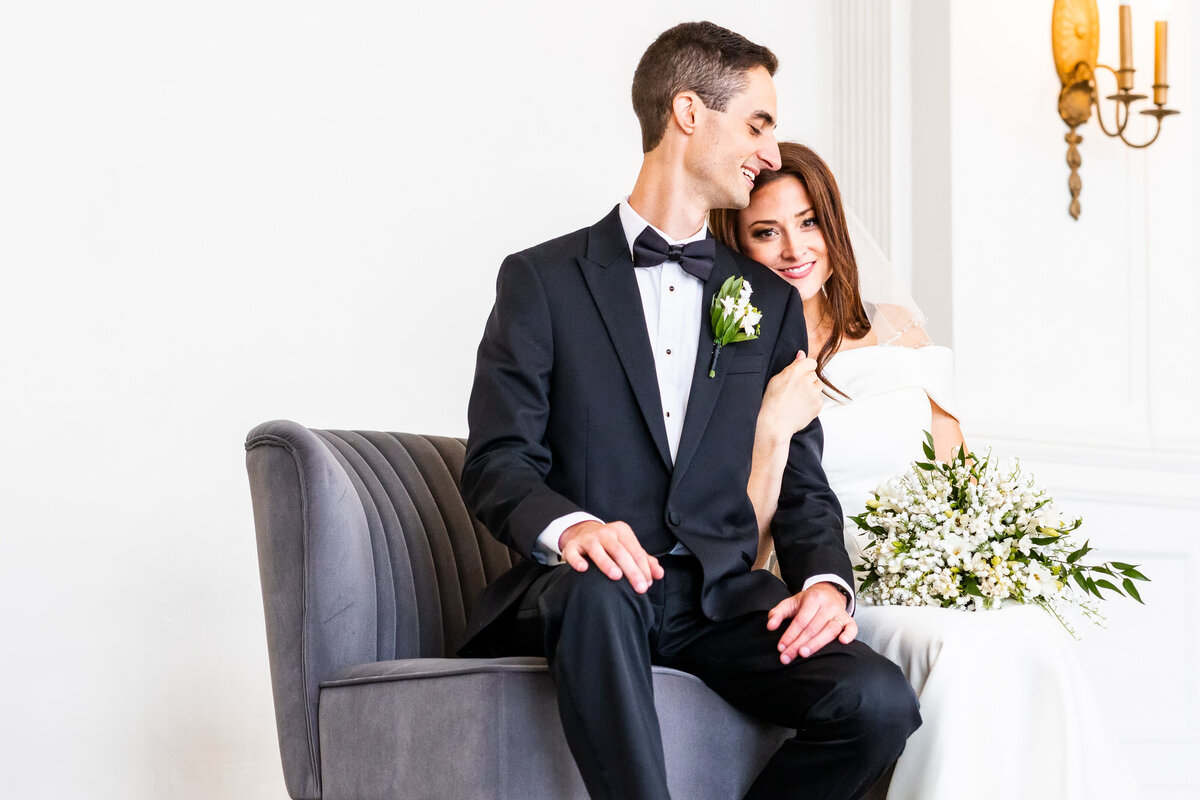 Bride and Groom sitting on couch snuggling.