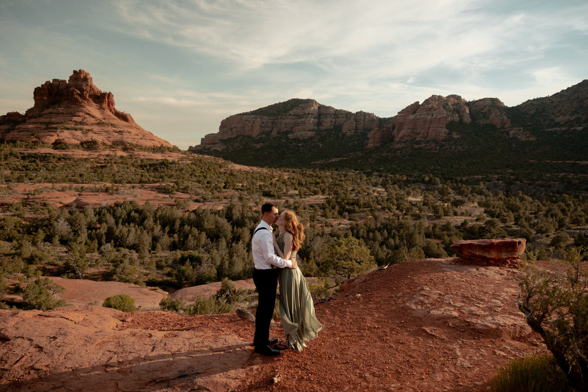 Couple standing against red rock backdrop during Sedona engagement session