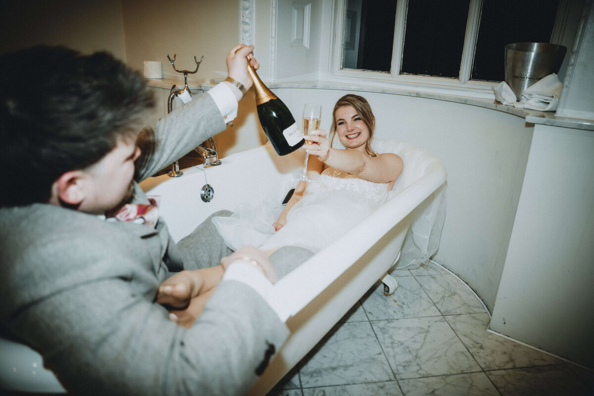buxted-park-wedding-couple-in-bath-with-champagne