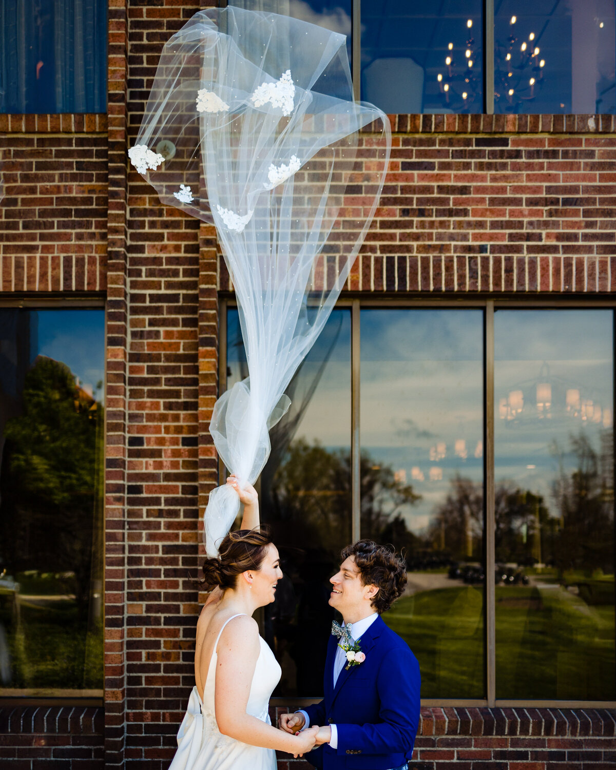 Wedding couples first look at Sylvania Country Club with the brides vail blowing straight up in the air