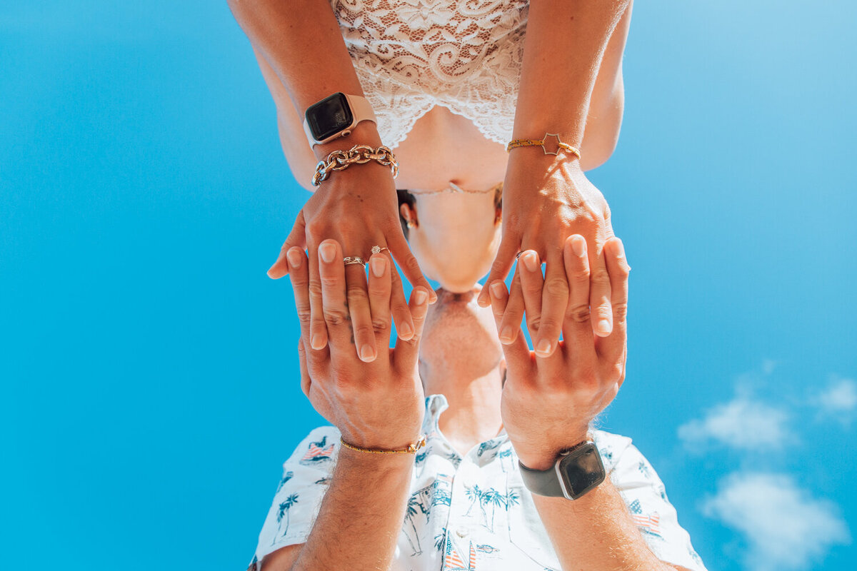 a  newly engaged couple kissing on a beach in Maui.