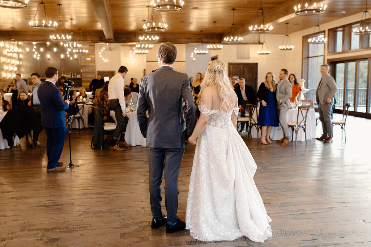 A bride and groom hold hands during their reception at Black Canyon Inn in Estes Park.