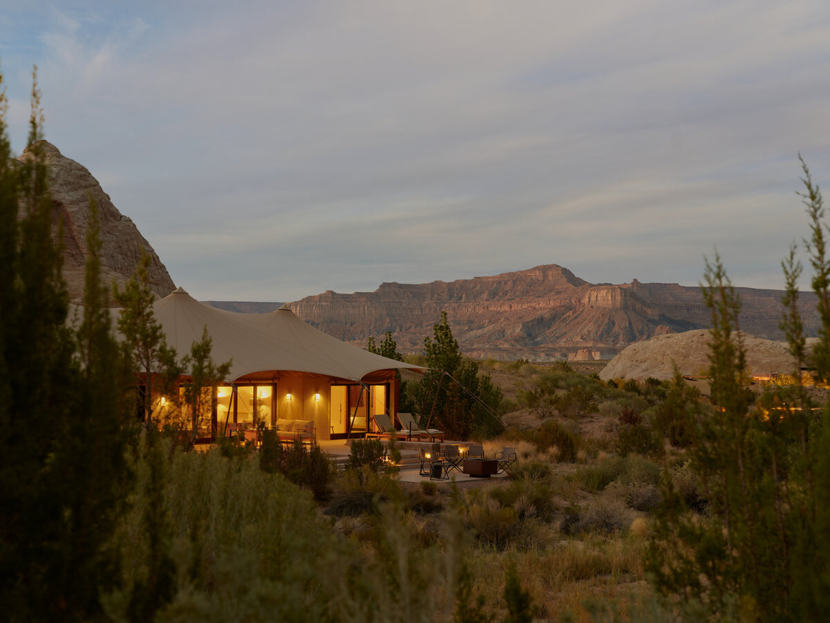 An exclusive desert retreat at Camp Sarika, Amangiri, USA, featuring luxurious tented pavilions set against the breathtaking rock formations of the Utah desert at sunset. 