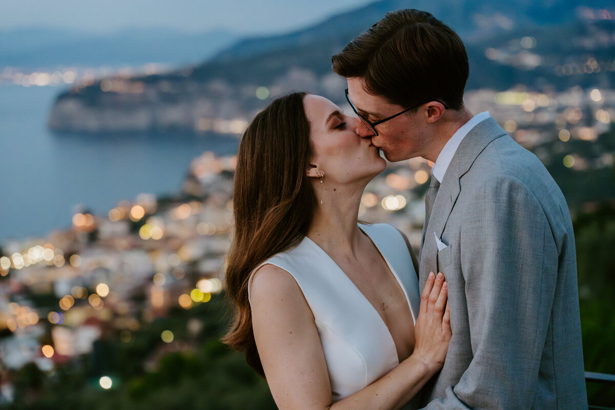 Bride and groom kissing on Sorrento terrace at sunset