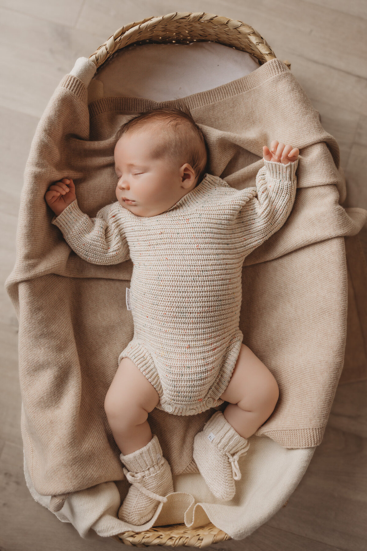 newborn baby posing in bassinet captured by Bie