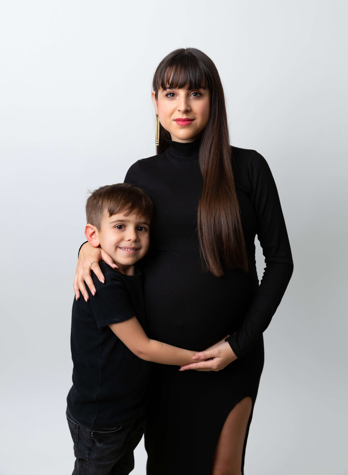 A pregnant happy mom with her son in black outfits for a maternity photoshoot in New York 