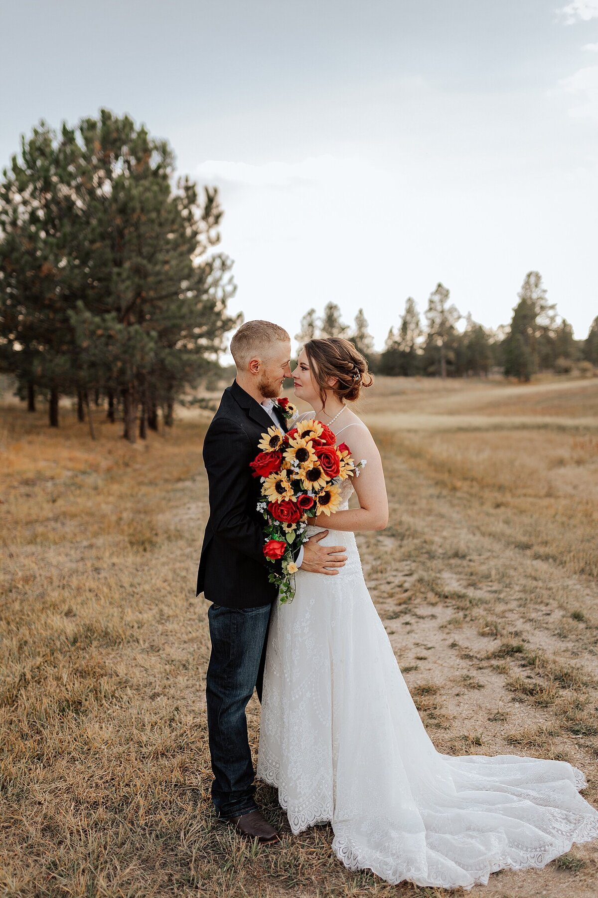 couple portrait of bride in white wedding dress and groom in tux with bouquet looking at each other. Photo taken by Michelle Betz Photography