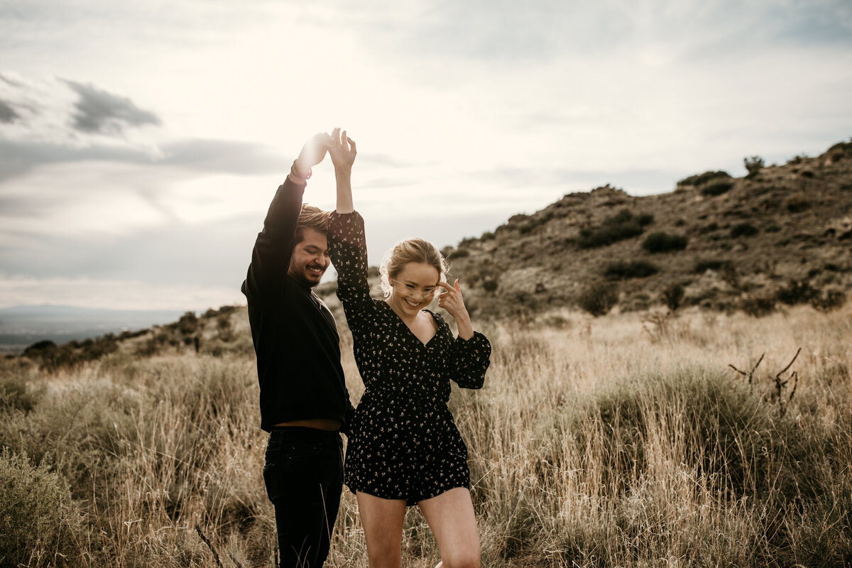 engaged couple dancing ing through the Albuquerque desert