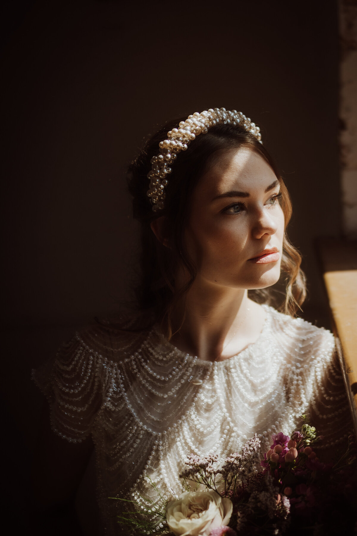 Bride staring out of window with sparkly dress on