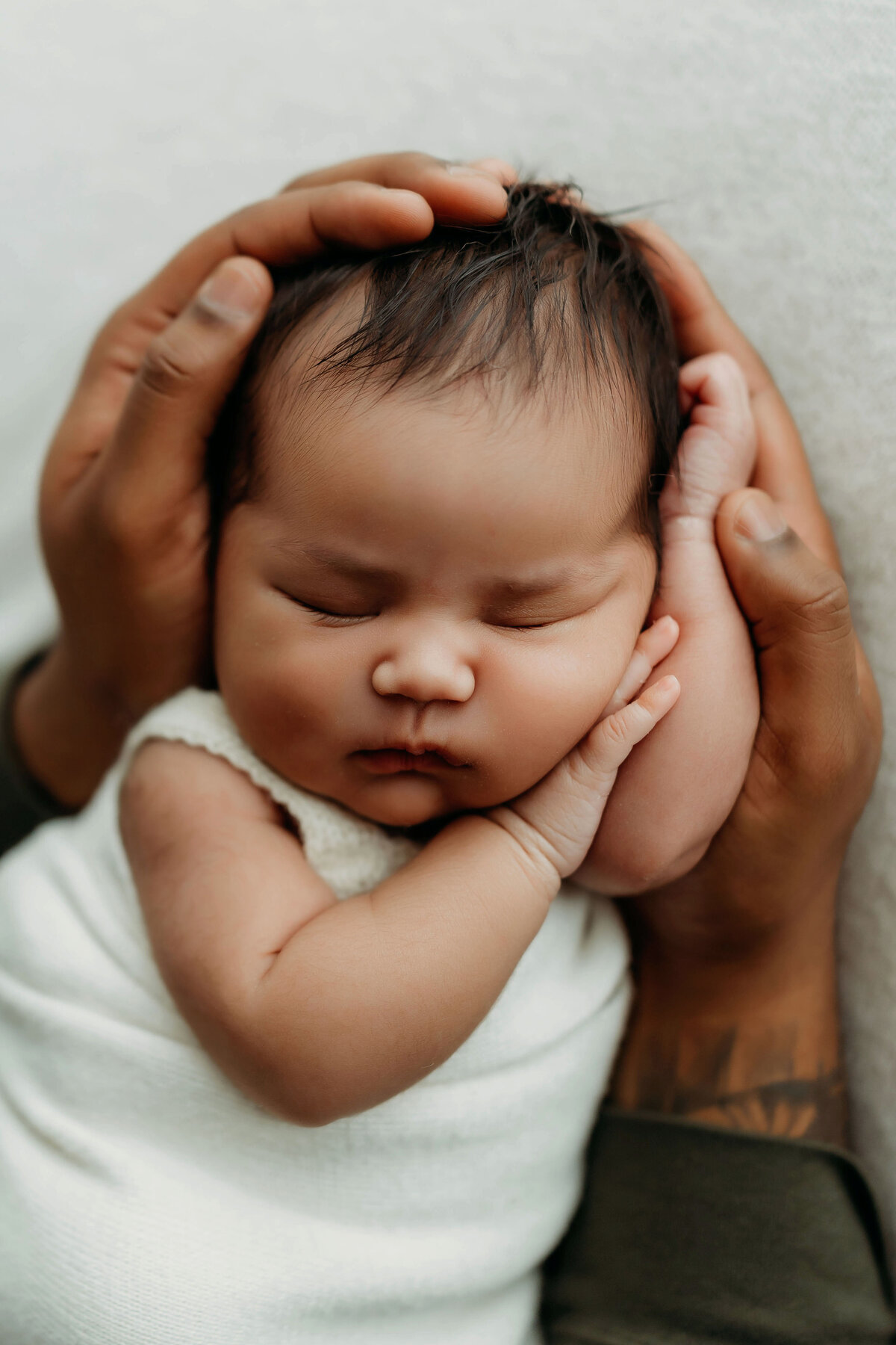 A Dad holds his newborn baby inside a Vancouver, Washington Studio