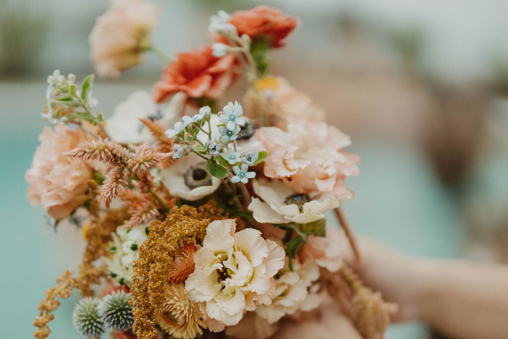 Outdoor tented wedding reception with peach and yellow flowers