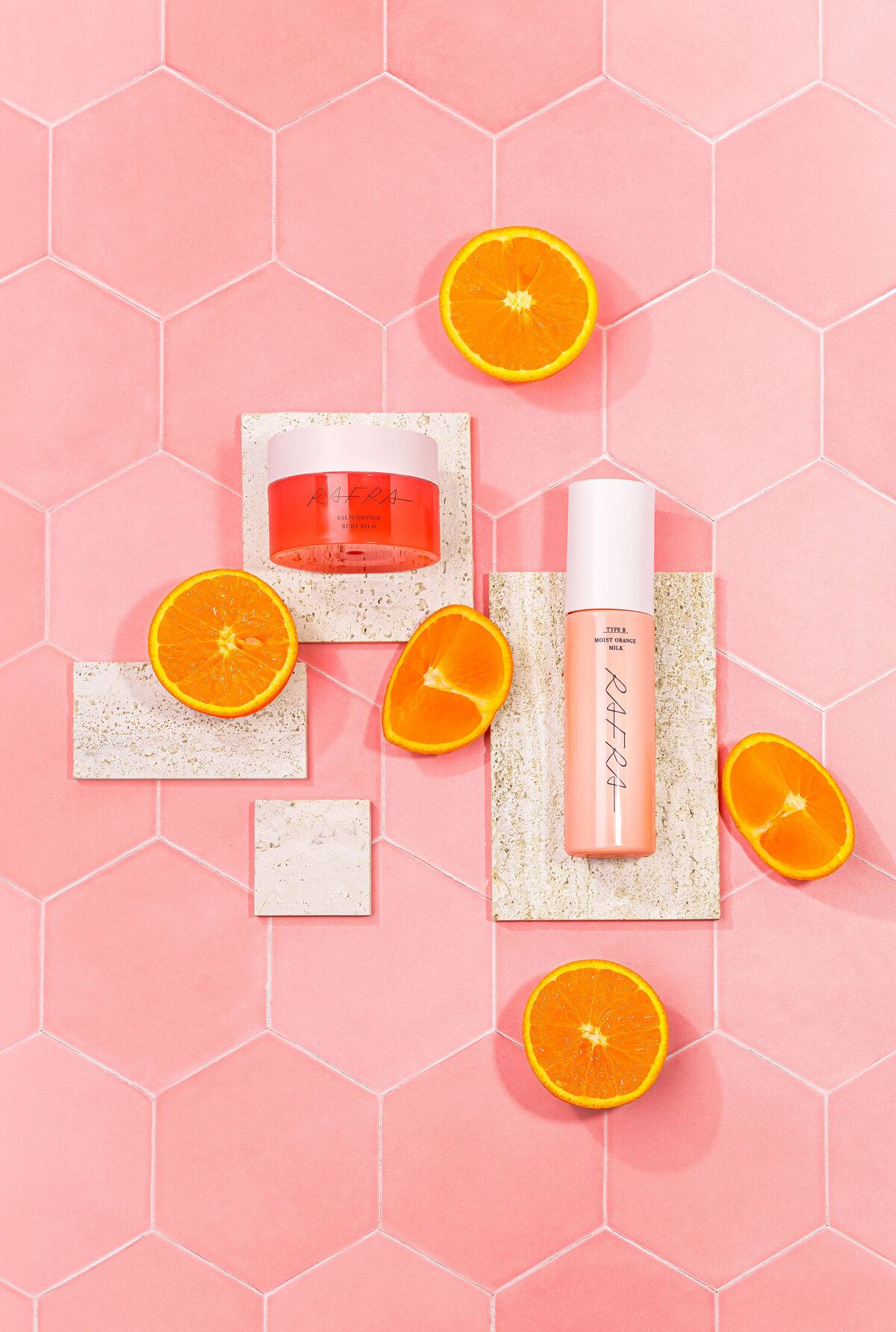 Photo de soins beauté avec agrumes sur fond rose texturé, mise en scène par Studio Helloday.