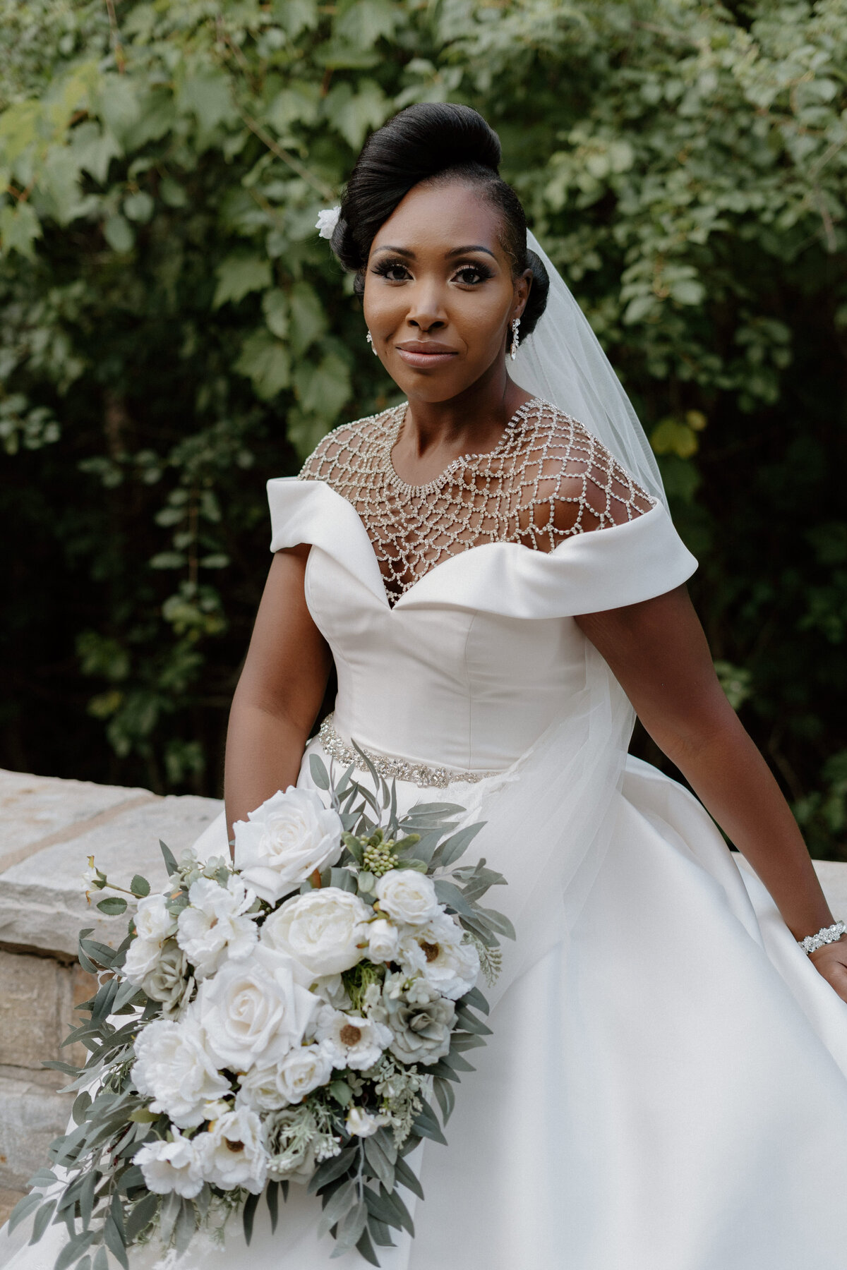 A bride of color smiling in her wedding dress for her solo portrait