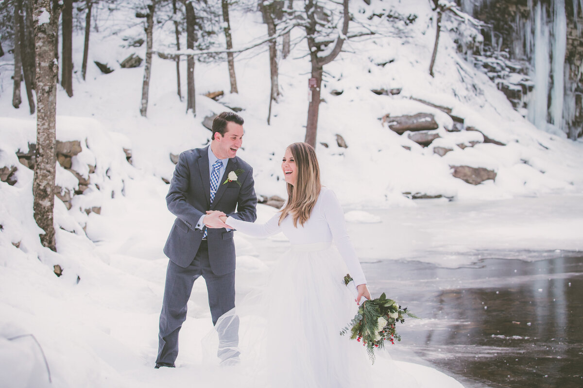 Bride and groom laugh during winter adventure elopement.