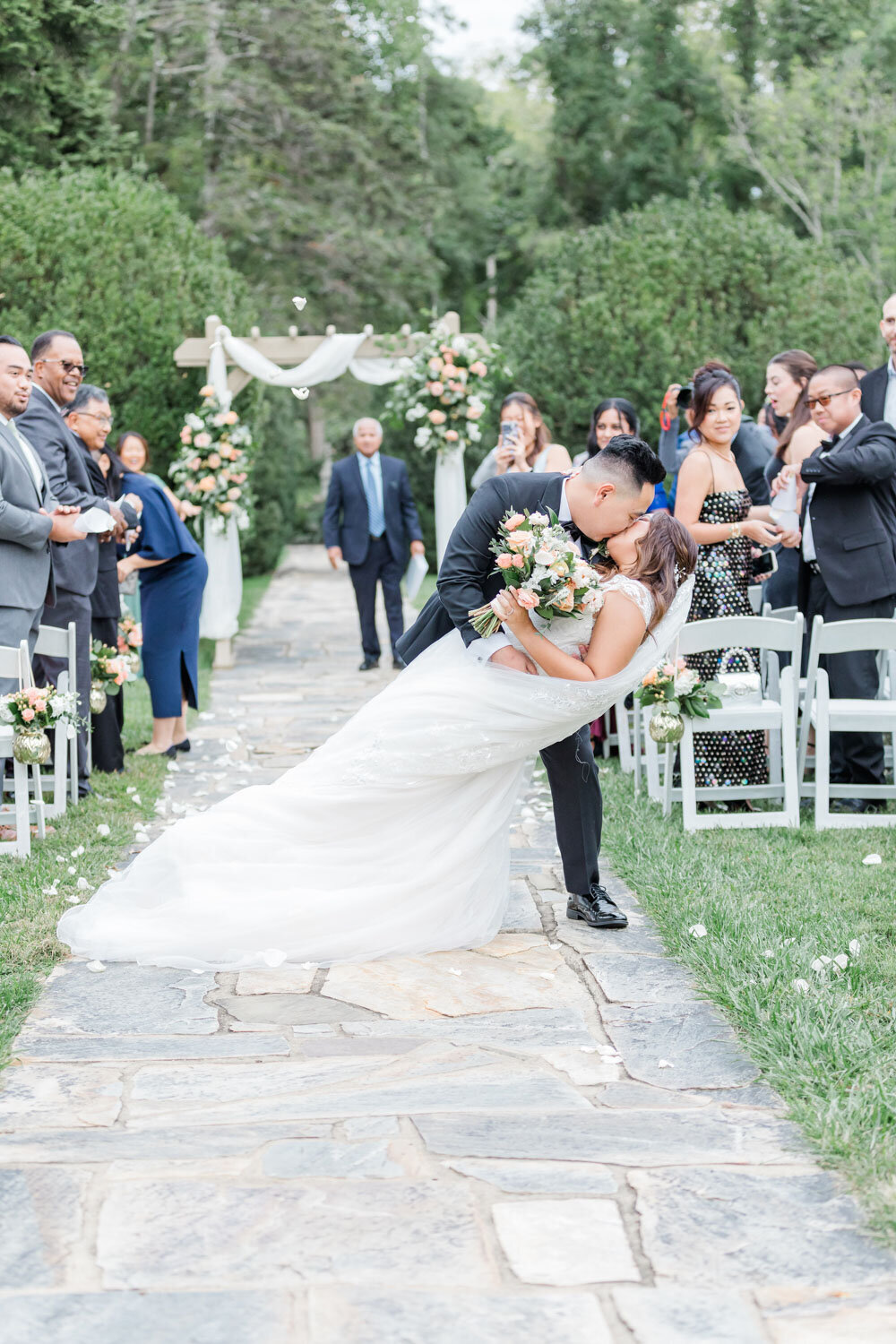Bride and groom doing deep kiss in the aisle