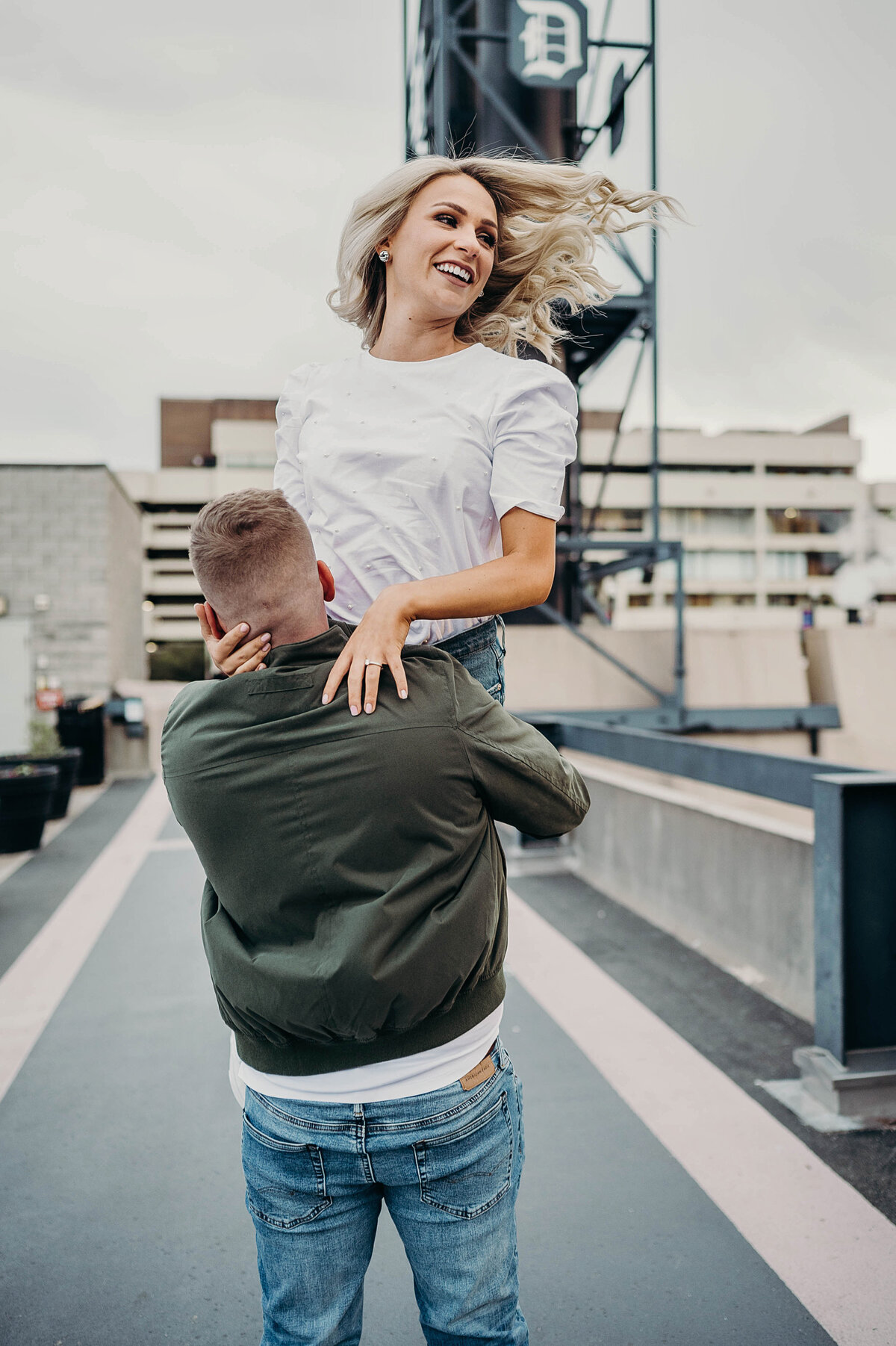 Joyful moment as a fiancé lifts their partner with the city skyline behind them, capturing their love story | Engagement Photographer Pittsburgh