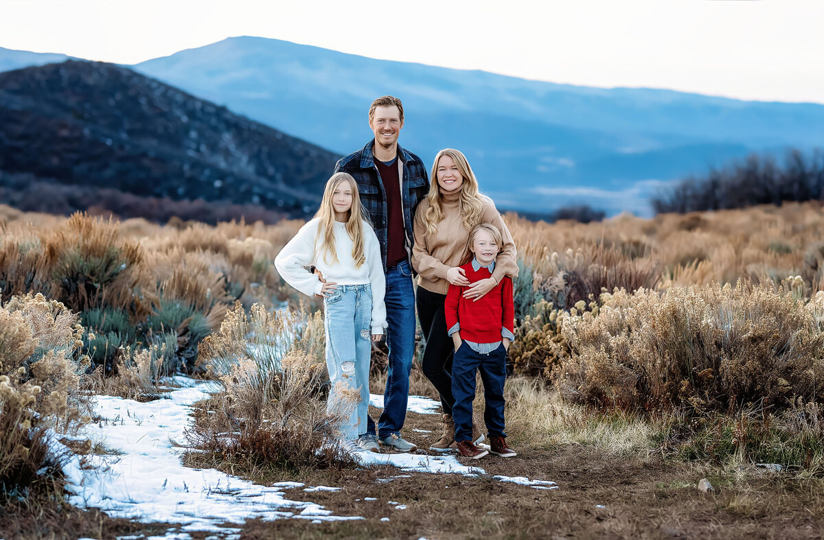 A nice looking family posing in front of the mountain ranges in Aspen, Colorado,