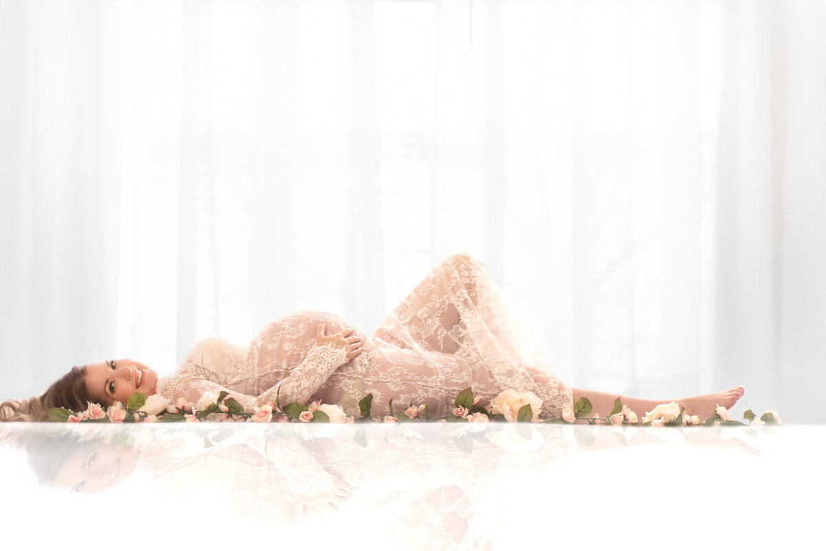 Soft studio maternity portrait with an elegant mother-to-be in a white setting, captured in Overland Park, Kansas. Perfect for timeless and minimalist maternity photography.