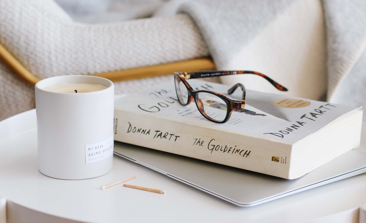 candle-unlit-with-books-glasses