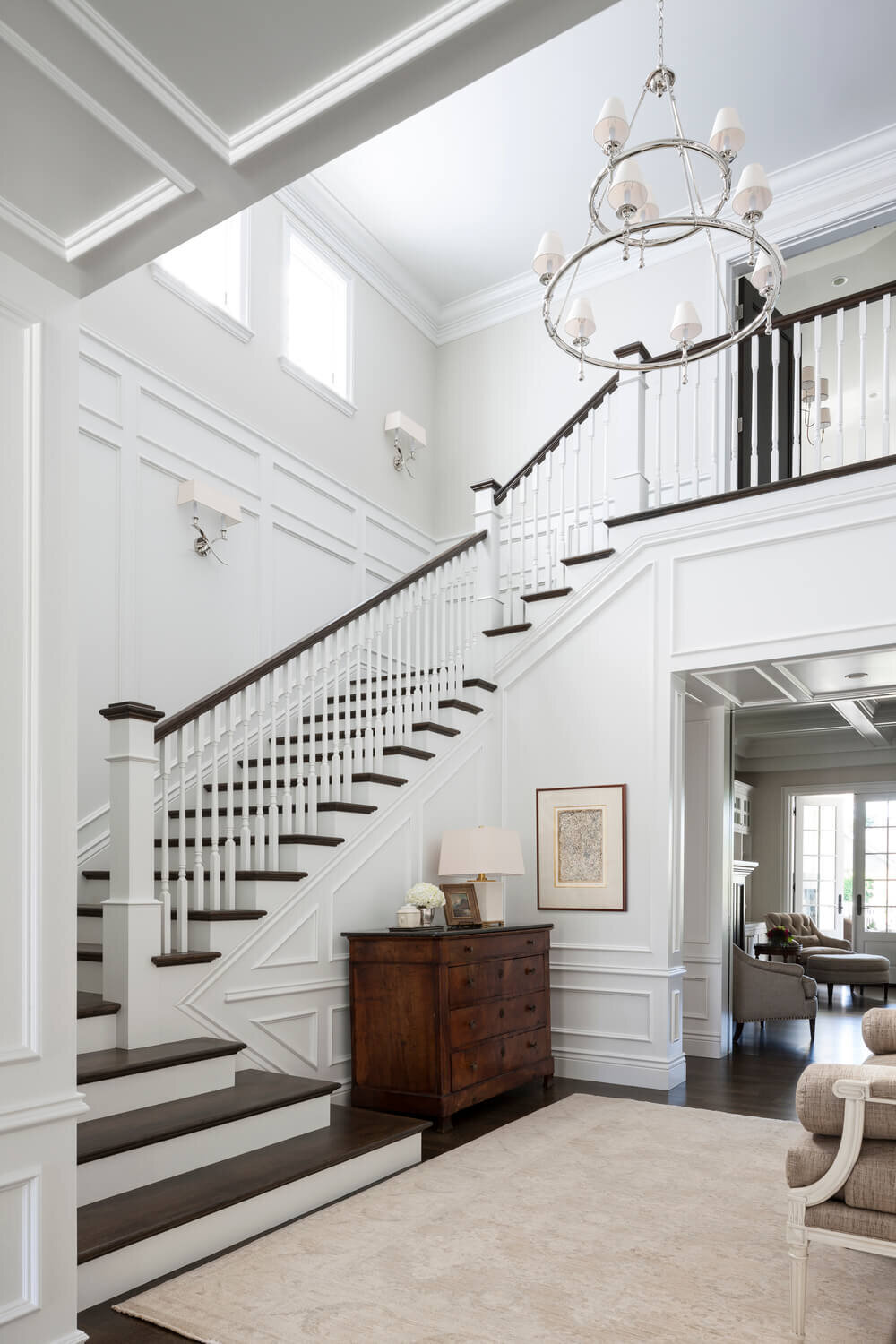 White-entryway-wood-staircase-crown-molding-antique-dresser