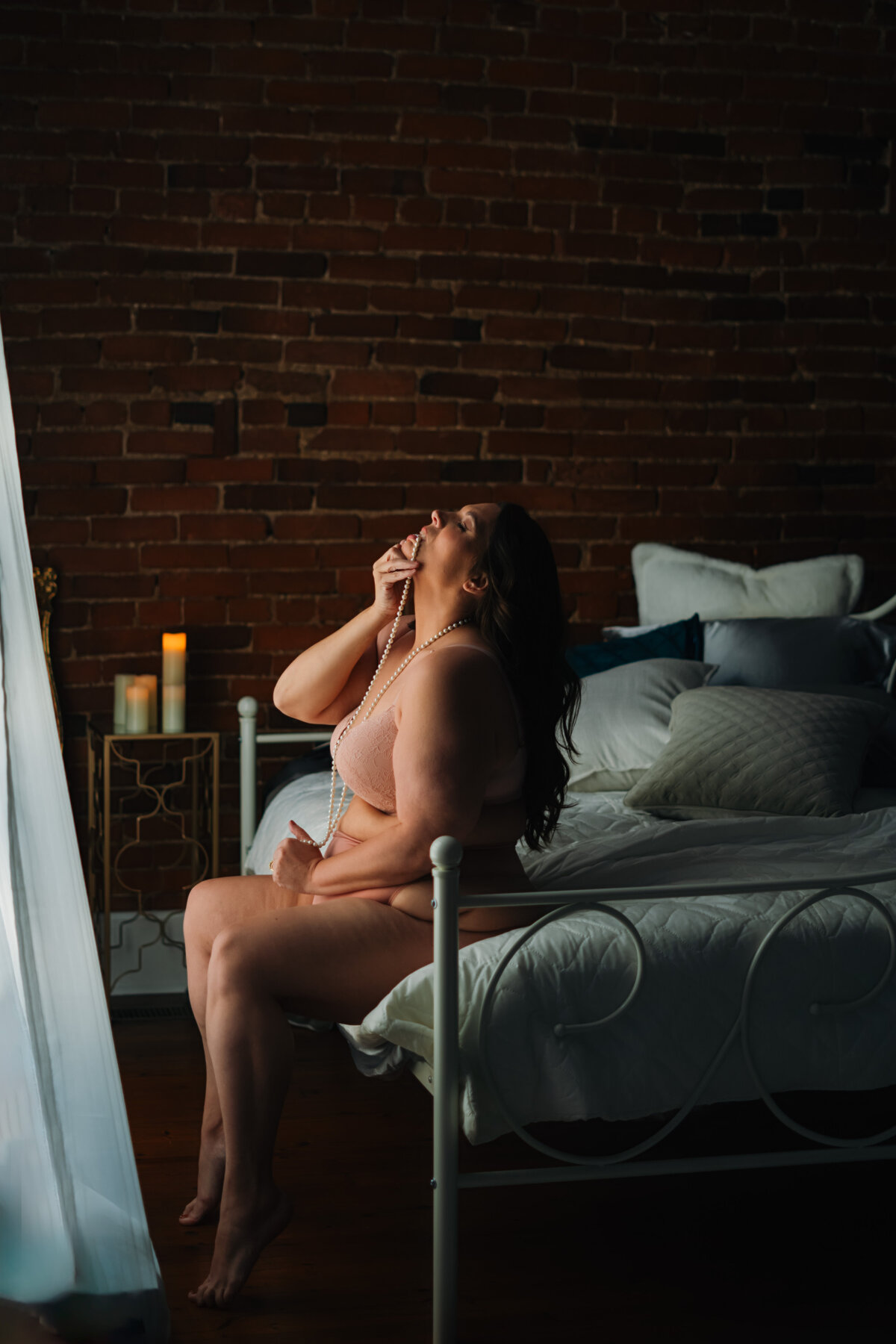 mature woman on bed for her nashville boudoir photography session