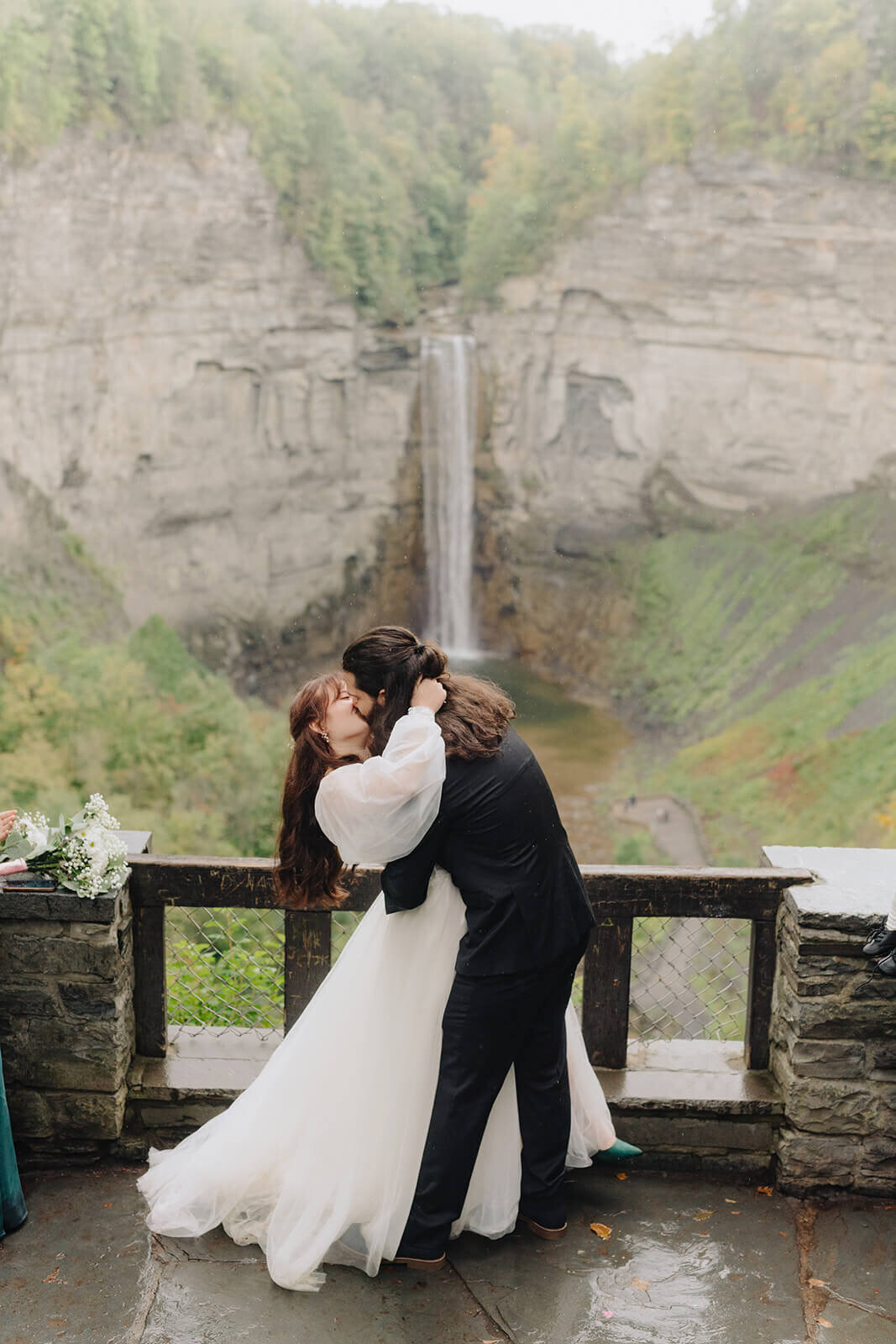 bride and groom hugging in front of a waterfall in Finger Lakes, NY
