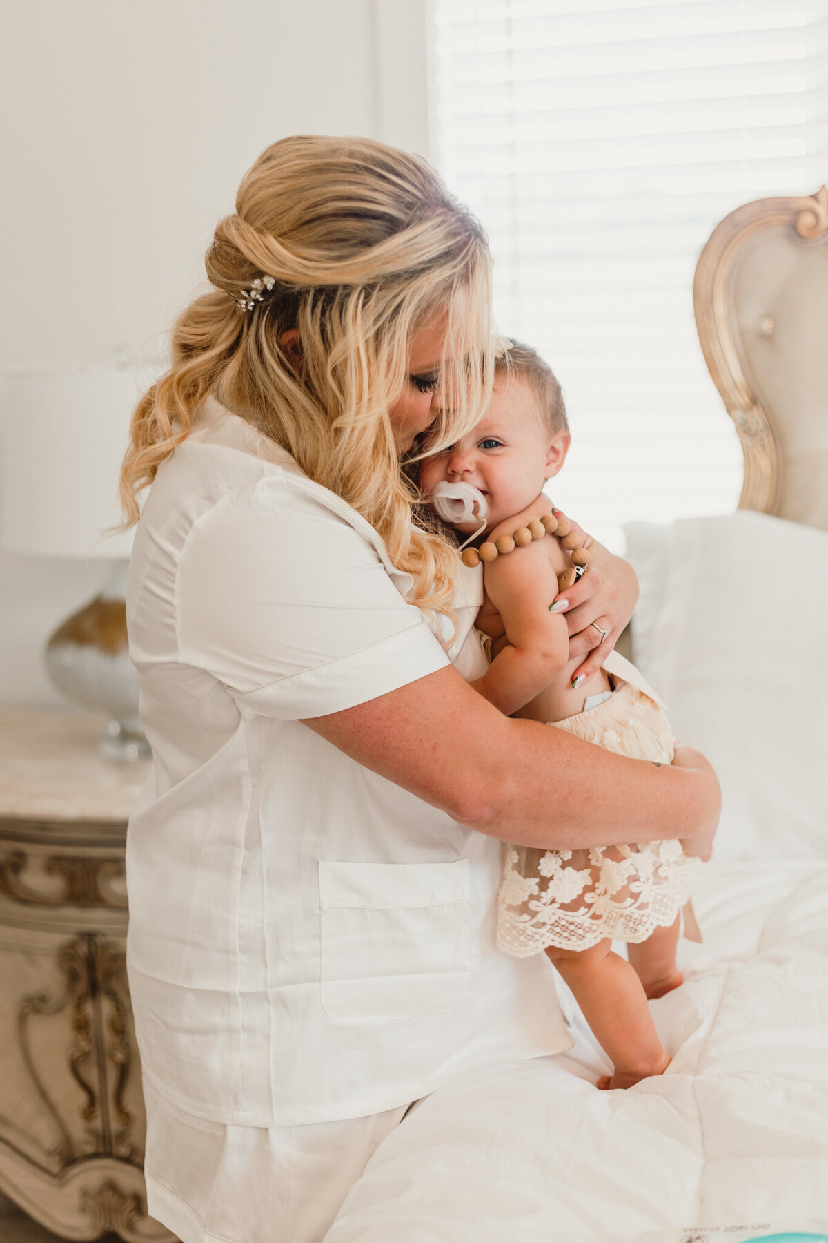 A tender moment between a mother and her young daughter during Charesa and Ethan’s wedding at Legacy Farm in Illinois. The mother, dressed in a white blouse, holds her daughter closely, sharing a sweet embrace. Captured by ShutterUp Photography.