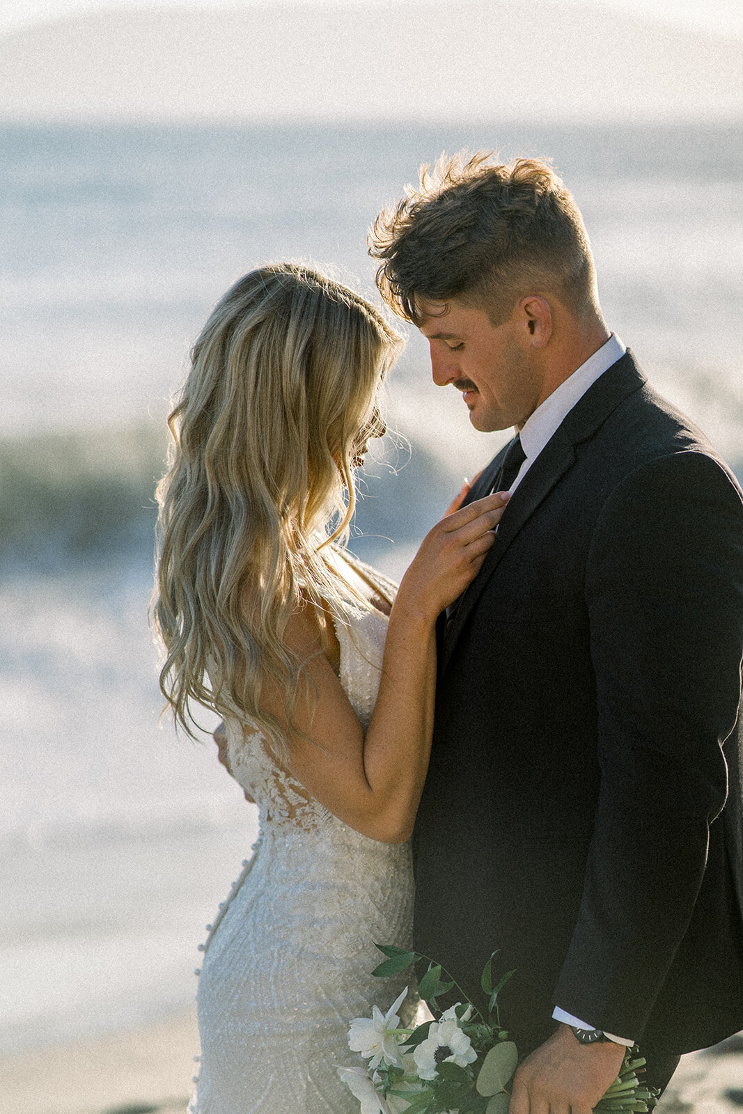 Bride and groom the beach at sunset at Dolphin Bay Resort in Pismo Beach, CA