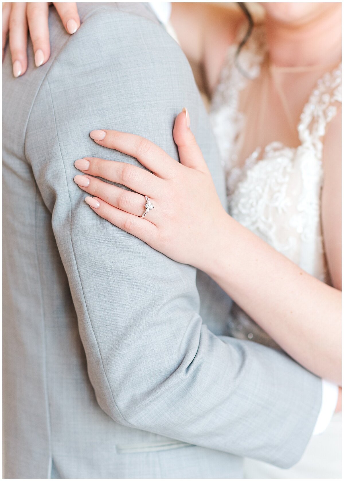 close up bride's ring hand on groom's arm with bride's hand on his bicep